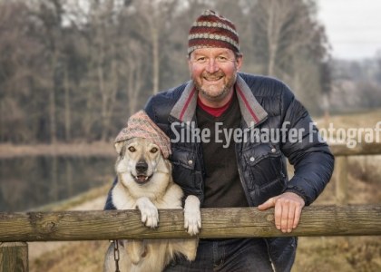 Portrait Mann mit Hund und Mütze.