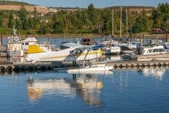 Kleiner Hafen mit Wasserflugzeug und Booten.